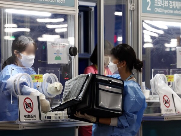 29일 오전 인천공항 제2터미널 코로나 검사센터에서 의료진이 검체를 옮기고 있다. 사진=연합뉴스
