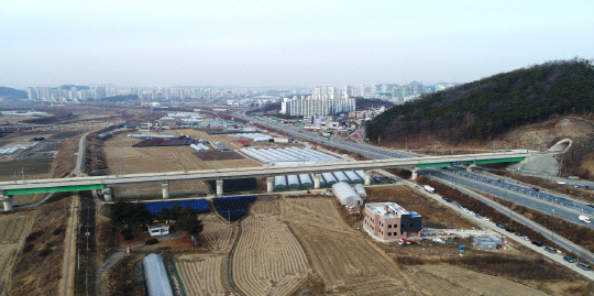 공중에서 본 KTX세종역 예정지. 오른쪽으로 세종-대전 국도1호선이 지나가고, 멀리 정부청사가 위치한 세종시 신도시가 보인다. 사진=세종시