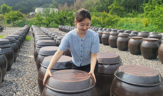 김민솔 대표가 청정한 산골 마당에서 숙성 중인 된장과 고추장 옹기를 살펴보고 있다.