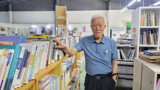 장인순 관장이 도서관 서가에 꽂혀있는 책에 대해 설명하고 있다.