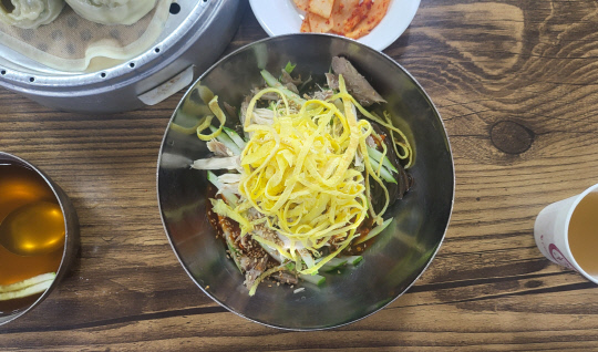 동구 비룡동 원미면옥은 잘게 찢은 닭고기와 지단, 삶은 계란, 오이채 등을 고명으로 얹혀준다.