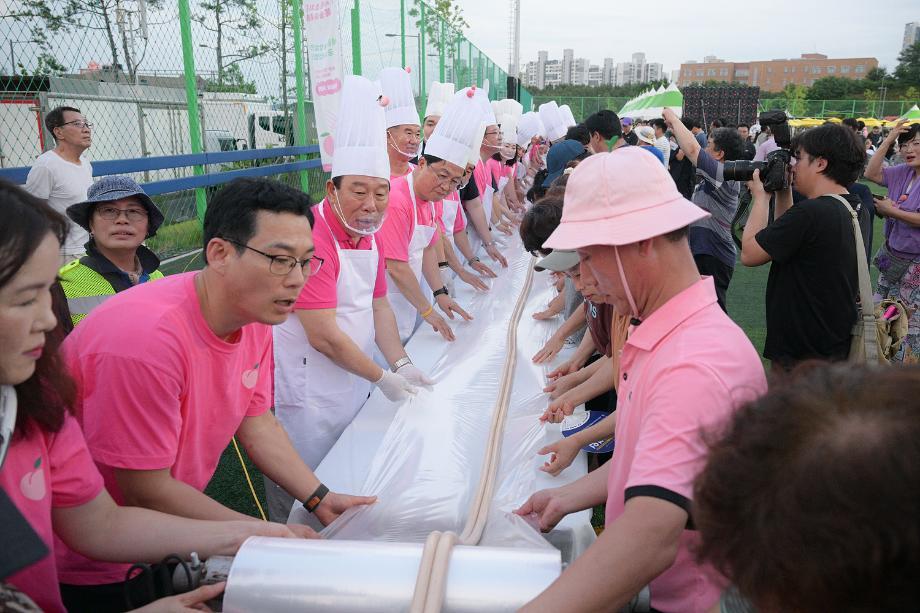 최민호 세종시장(왼쪽에서 세번째)이 지난해 세종조치원복숭아축제에서 '116m복숭아 가래떡뽑기' 행사에 참여하고 있다. 세종시 제공