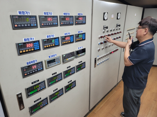 유정TMR 직원이 사료 자동 생산라인의 판넬을 조작하며 품질관리에 최선을 다하고 있다. 유정TMR 제공