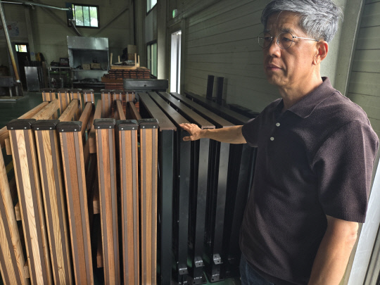 김기배대표가 고열처리된 목재로 제조된 패널을 설명하고 있다.