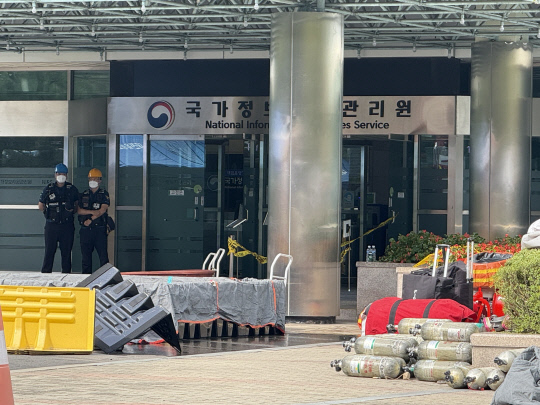 지난 26일 오후 8시 20분쯤 대전 유성구 국가정보자원관리원 5층 전산실 내부에서 화재가 발생한 가운데 27일 오후 소방당국이 화재 현장에서 꺼낸 배터리 등을 방수포에 덮고 냉각 작업을 벌이고 있다.