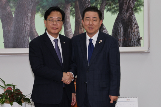 더불어민주당 김병기 원내대표와 국민의힘 송언석 원내대표(왼쪽)가 25일 서울 여의도 국회에서 대장동 사건 항소포기 여야 국정조사 등 쟁점을 협상하기에 앞서 악수하고 있다. 연합뉴스